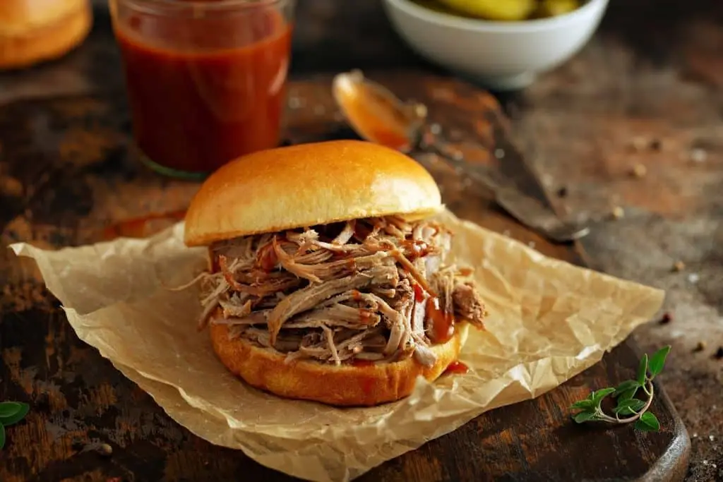 Pulled pork sandwich on a brioche bun with pickles