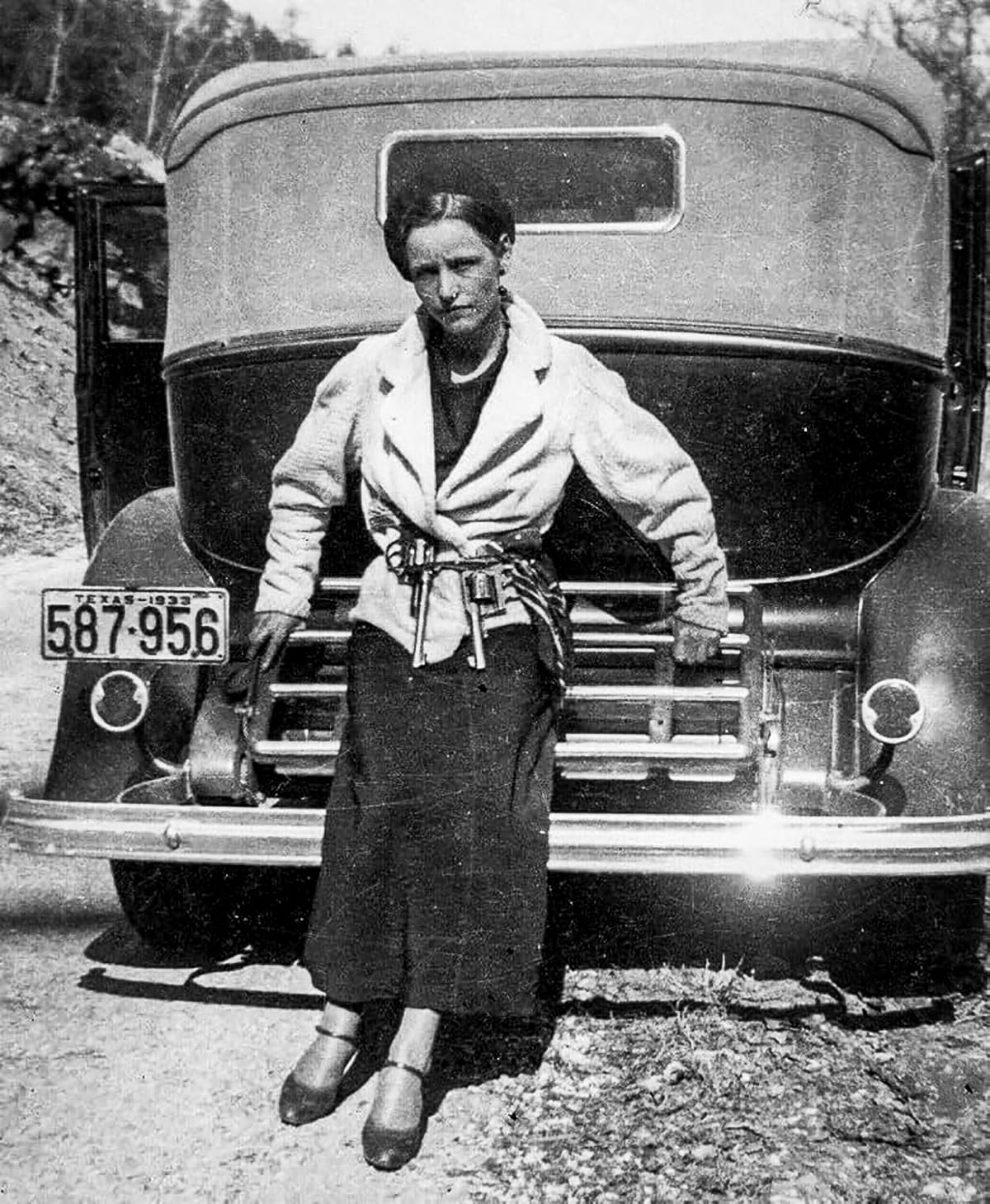 Bonnie Parker of Bonnie and Clyde fame with two revolvers in her belt.