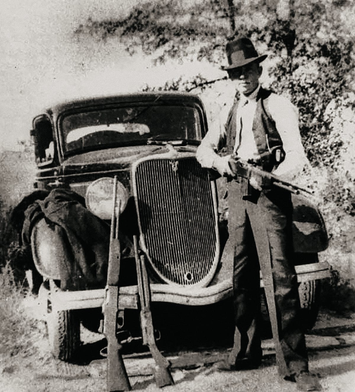 Clyde Barrow of Bonnie and Clyde with BARs and a Model 11 shotgun